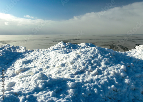 winter landscape by the sea, snowy, interesting ice shapes on the sea shore, dunes covered with a white layer of shining snow