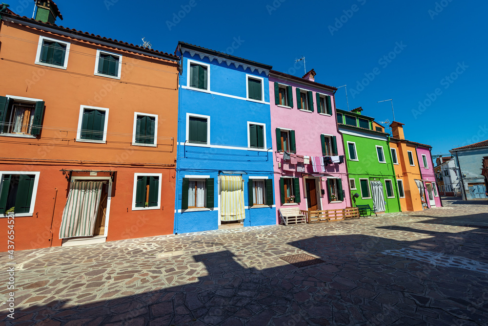 Beautiful houses with bright colors (multi coloured) in Burano island in a sunny spring day with clear sky. Venice lagoon, UNESCO world heritage site, Veneto, Italy, southern Europe.