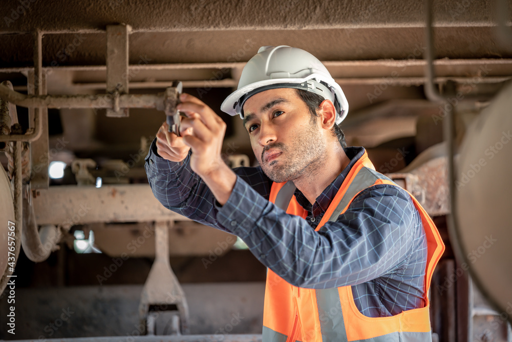 Engineer under inspection and checking construction process railway switch and checking work on railroad station .Engineer wearing safety uniform and safety helmet in work. Engineer under inspection and checking construction process railway switch and checking work on railroad station .Engineer wearing safety uniform and safety helmet in work.