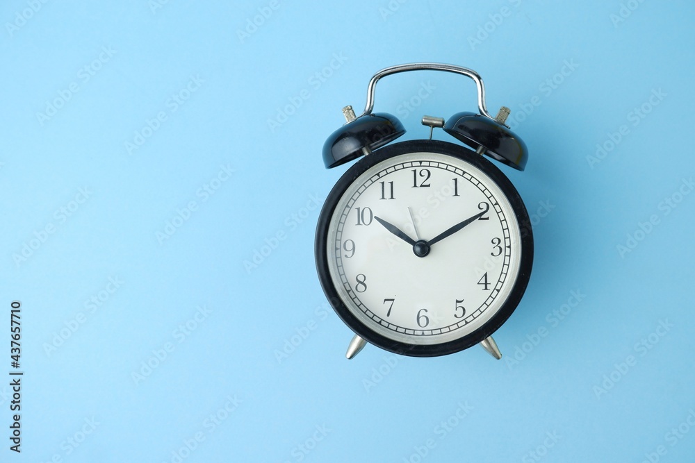 black alarm clock isolated on blue background black alarm clock isolated on blue background