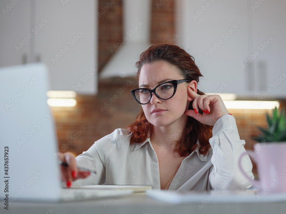 Businesswoman working on laptop computer sitting at home Businesswoman working on laptop computer sitting at home