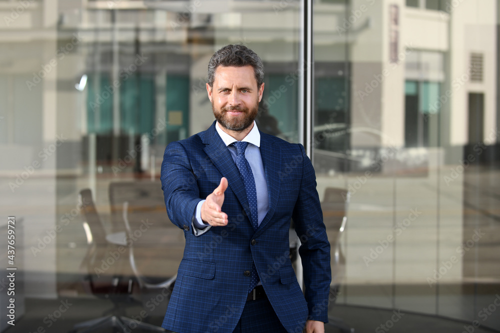 Urban business man. Casual businessman shaking hands. A businessman with an open hand ready to seal a deal. Urban business man. Casual businessman shaking hands. A businessman with an open hand ready to seal a deal.
