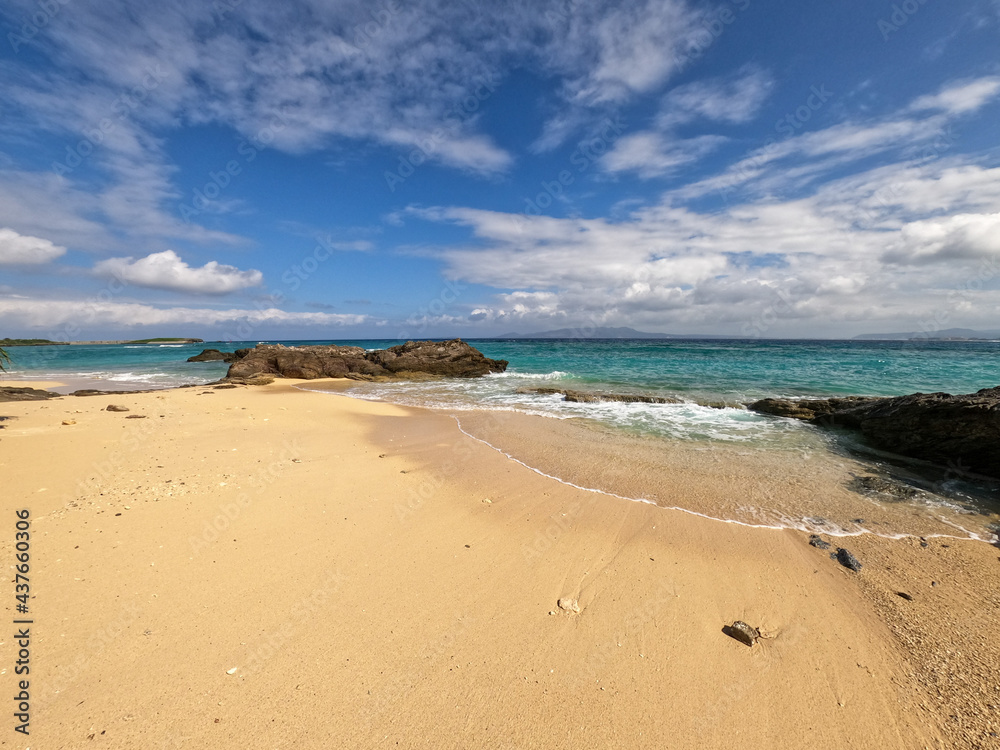 青い空と白い雲の下の青く美しい沖縄のビーチ