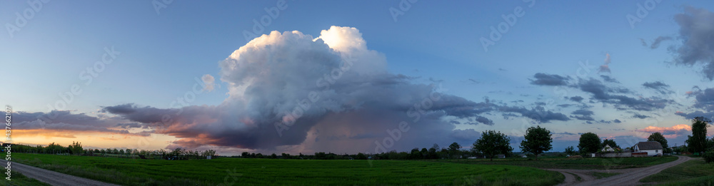 Storm cloud over a field of green wheat