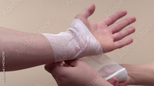 Close-up shot of the wrist of a man's hand. A sore or wound on the arm. Wound treatment. Wrapping the bandage on the arm