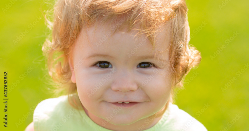 Caucasian child portrait close up. Baby face. Smiling infant, cute smile. Summer outdoor park.