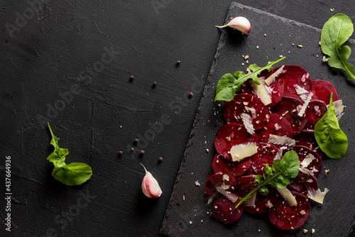 Fototapeta Naklejka Na Ścianę i Meble -  Young beet carpaccio with parmesan, nuts, arugula and garlic with olive oil. Vegan food.