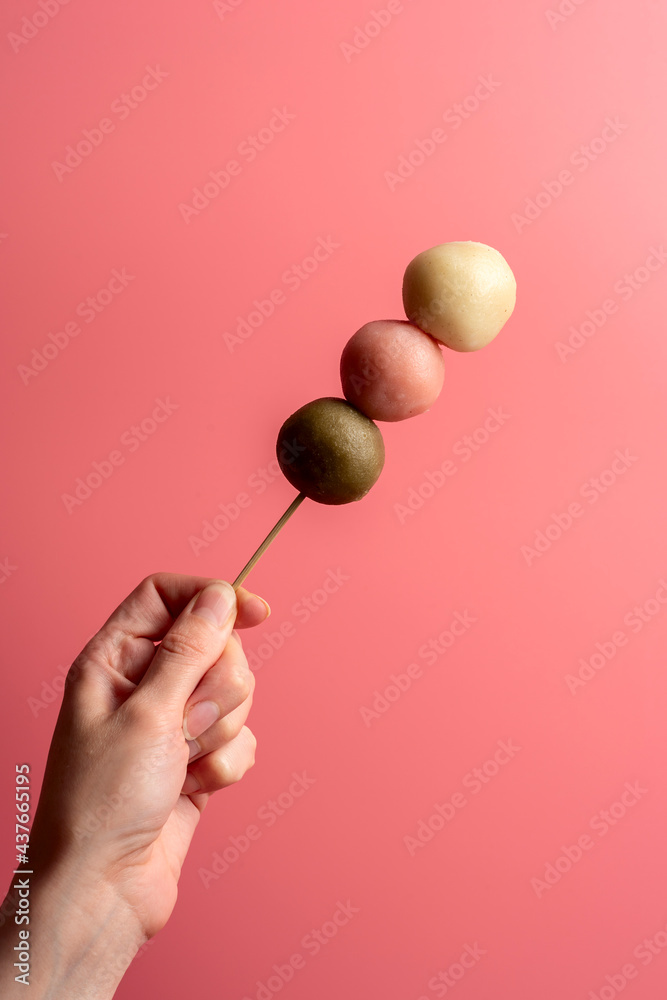 Japanese Dango multicolor dessert in the woman hand Japanese Dango multicolor dessert in the woman hand