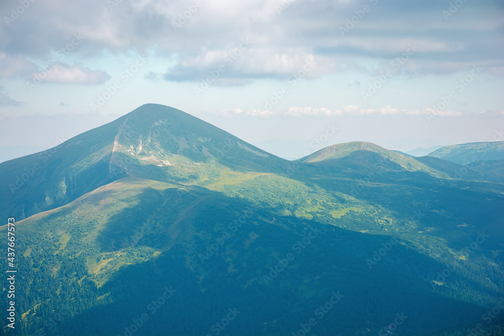 carpathian mountain landscape in summer. hoverla peak and chornohora ridge in the distance. cloudy afternoon weather