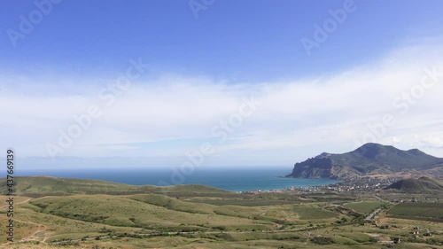 Beautiful movement of clouds over the volcano Karadag, the village of Koktebel and vineyards. Black Sea, Crimea. Timelapse.