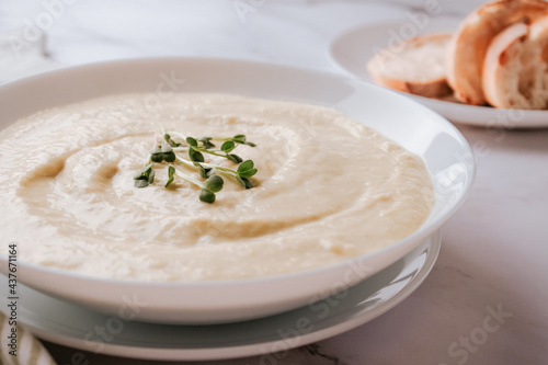 Closeup view of white bowl with mushroom cream soup - healthy food concept. Classic recipe. Selective focus