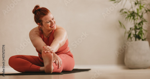 Obraz na plátne Smiling woman doing stretching leg workout