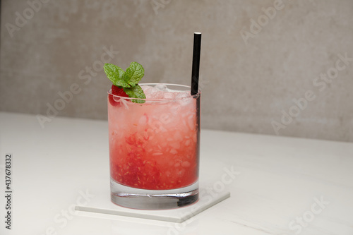 Raspberry mojito cocktail with raspberries, lime, mint and ice in glass on gray background. Summer cold alcoholic non-alcoholic drinks, beverages and cocktails. Front view with copy space.