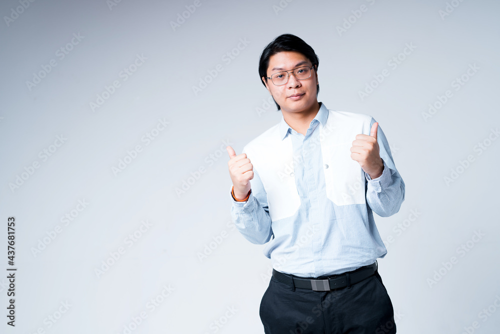 Handsome asian businessman in shirt and trousers raising thumbs up and looking at camera Handsome asian businessman in shirt and trousers raising thumbs up and looking at camera