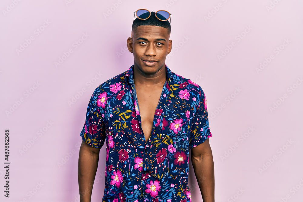 Young black man wearing hawaiian shirt and sunglasses with a happy and cool smile on face. lucky person. - obrazy, fototapety, plakaty 