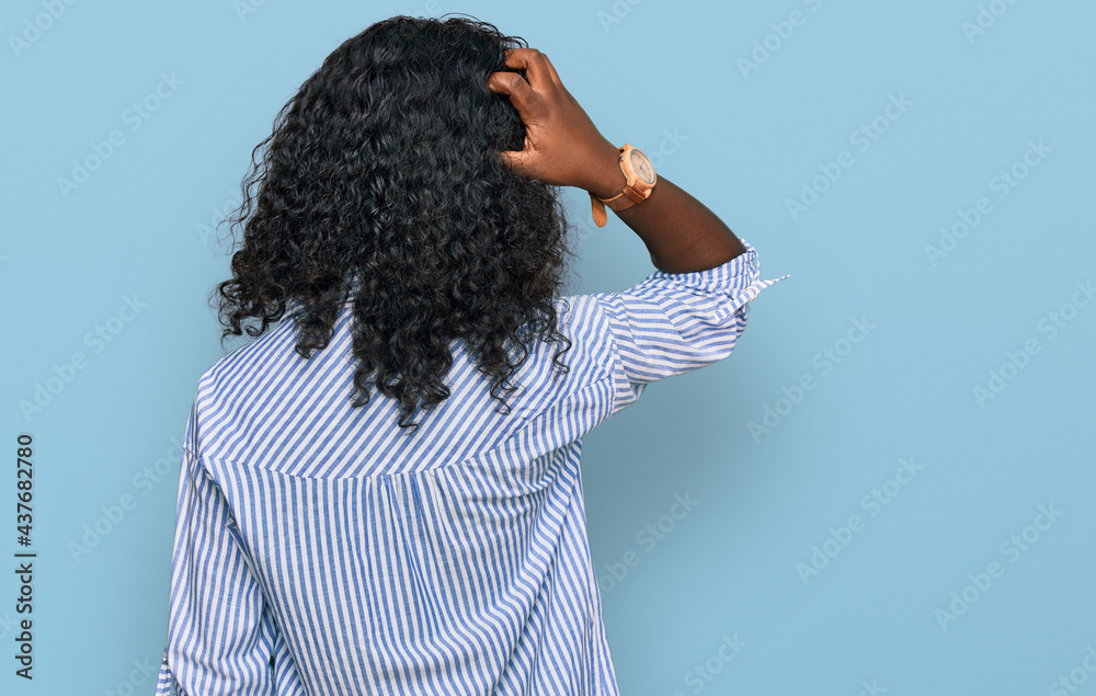 Beautiful african young woman wearing casual clothes and glasses backwards thinking about doubt with hand on head Beautiful african young woman wearing casual clothes and glasses backwards thinking about doubt with hand on head