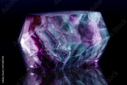 Macro mineral stone Fluorite crystal on a black background © Minakryn Ruslan 