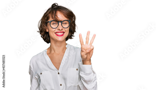Young hispanic woman wearing business style and glasses showing and pointing up with fingers number three while smiling confident and happy.