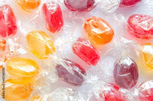 multicolored lollipops candy in transparent packaging background