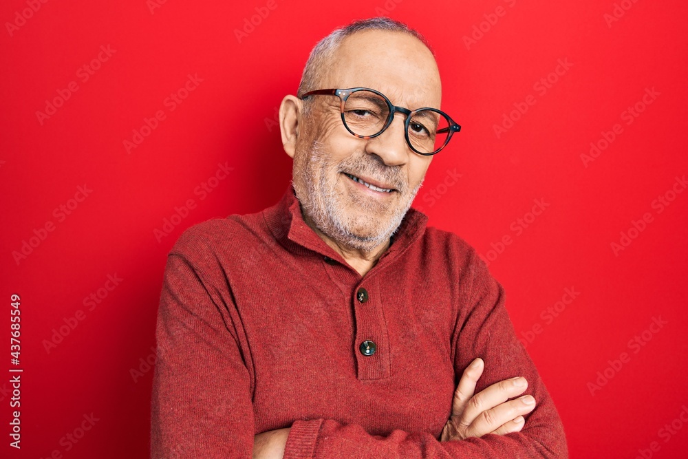 Handsome mature man wearing casual sweater and glasses happy face smiling with crossed arms looking at the camera. positive person.