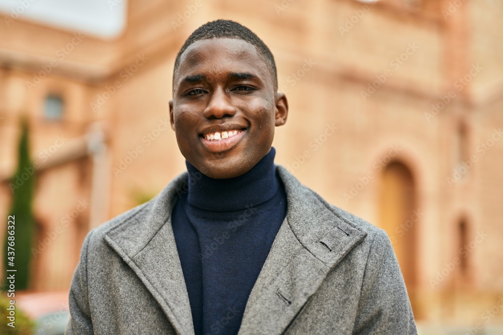 Obraz premium Young african american man smiling happy standing at the city