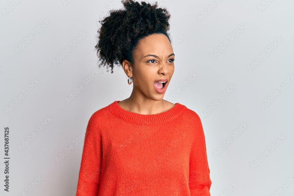 Young african american girl wearing casual clothes angry and mad screaming frustrated and furious, shouting with anger. rage and aggressive concept. Young african american girl wearing casual clothes angry and mad screaming frustrated and furious, shouting with anger. rage and aggressive concept.