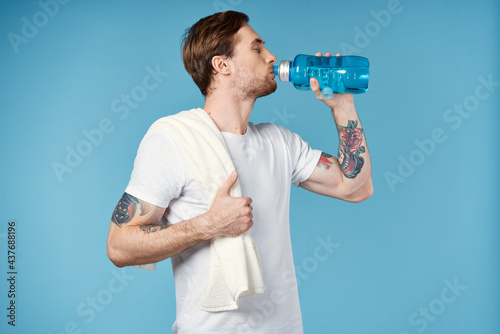 sports man drinking water from a bottle Sport Fitness towel on his shoulder