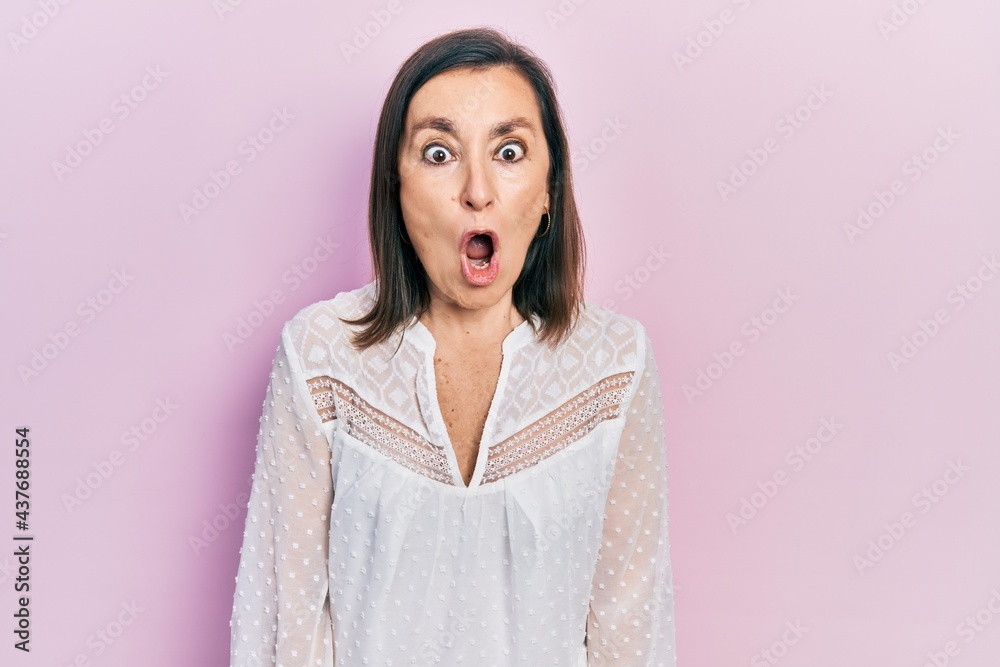 Fototapeta premium Middle age hispanic woman wearing casual clothes afraid and shocked with surprise expression, fear and excited face.