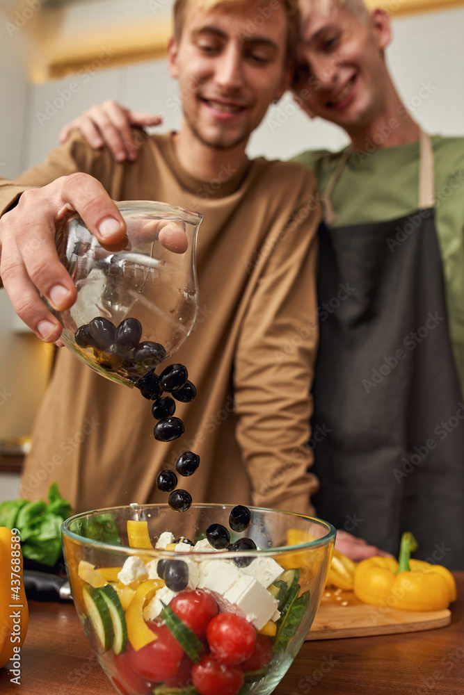 Selective focus on fresh salad cooked by male pair Selective focus on fresh salad cooked by male pair