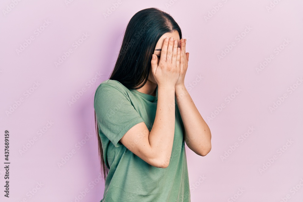 Beautiful woman with blue eyes wearing casual t shirt with sad expression covering face with hands while crying. depression concept. Beautiful woman with blue eyes wearing casual t shirt with sad expression covering face with hands while crying. depression concept.