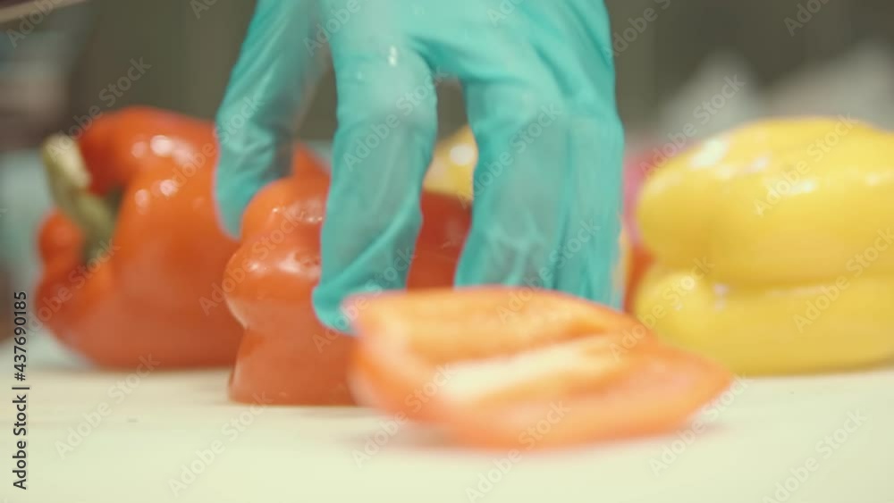 Cook cuts ripe red and yellow peppers with sharp knife. Preparation of ingredients for preparation of Mexican dish tacos with vegetables and hot spices. Cook cuts ripe red and yellow peppers with sharp knife. Preparation of ingredients for preparation of Mexican dish tacos with vegetables and hot spices.