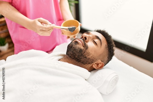 Man reciving facial treatment at beauty center. photo