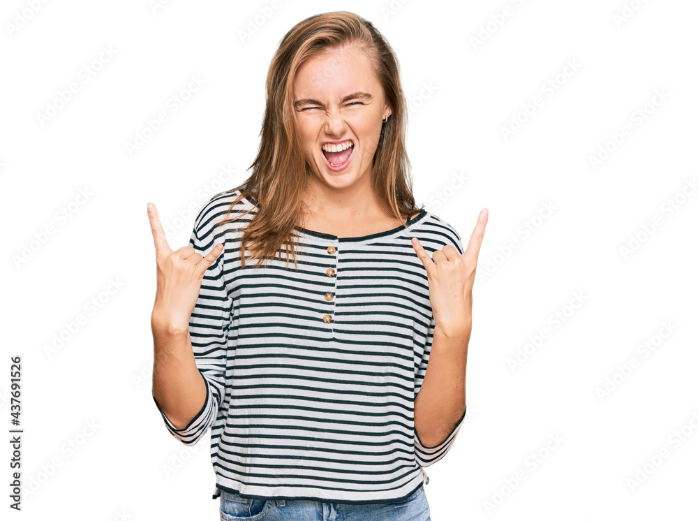Beautiful blonde woman wearing casual clothes shouting with crazy expression doing rock symbol with hands up. music star. heavy concept. Beautiful blonde woman wearing casual clothes shouting with crazy expression doing rock symbol with hands up. music star. heavy concept.