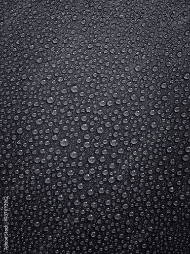 vertical background: water droplets with highlights on a dark surface