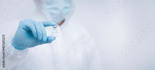 Close Up man doctor or scientist in uniform wearing a face mask with a stethoscope holding COVID-19 vaccine, Healthcare And Medical concept, vaccine Concept fight against virus Covid or Coronavirus