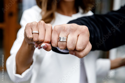 the bride and groom clenched their hands into a fist and show white gold rings