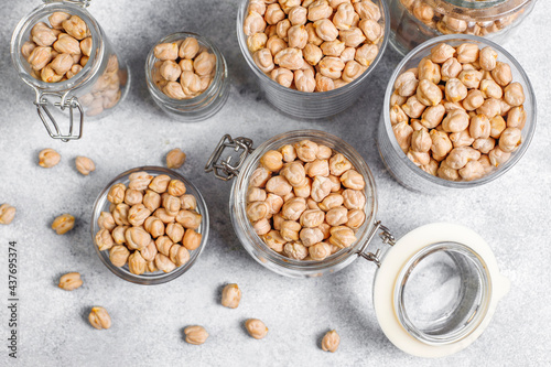 Uncooked dried chickpeas in a different glass jars and bowls.