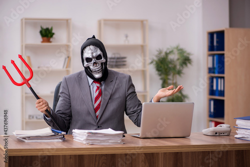 Devil businessman employee sitting at workplace