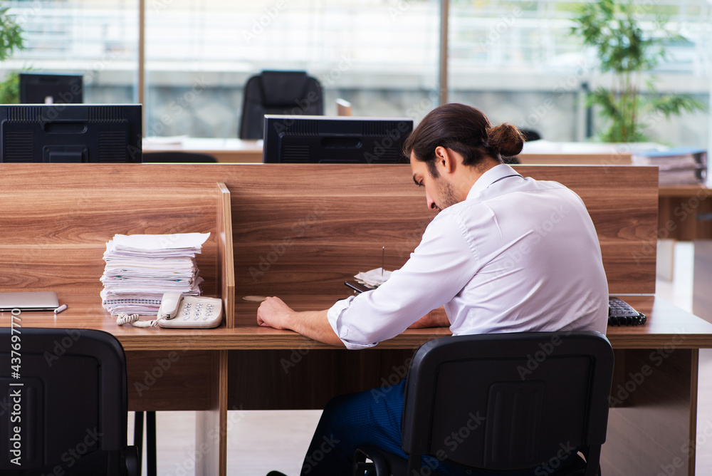 Young male employee and too many work in the office Young male employee and too many work in the office