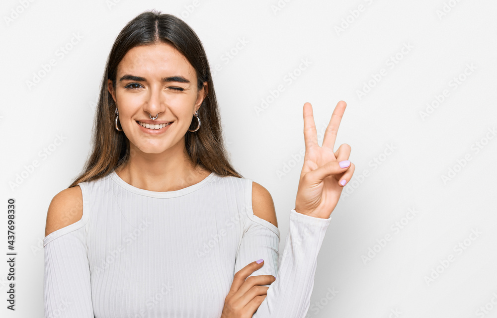 Young hispanic woman wearing casual clothes smiling with happy face winking at the camera doing victory sign. number two. Young hispanic woman wearing casual clothes smiling with happy face winking at the camera doing victory sign. number two.