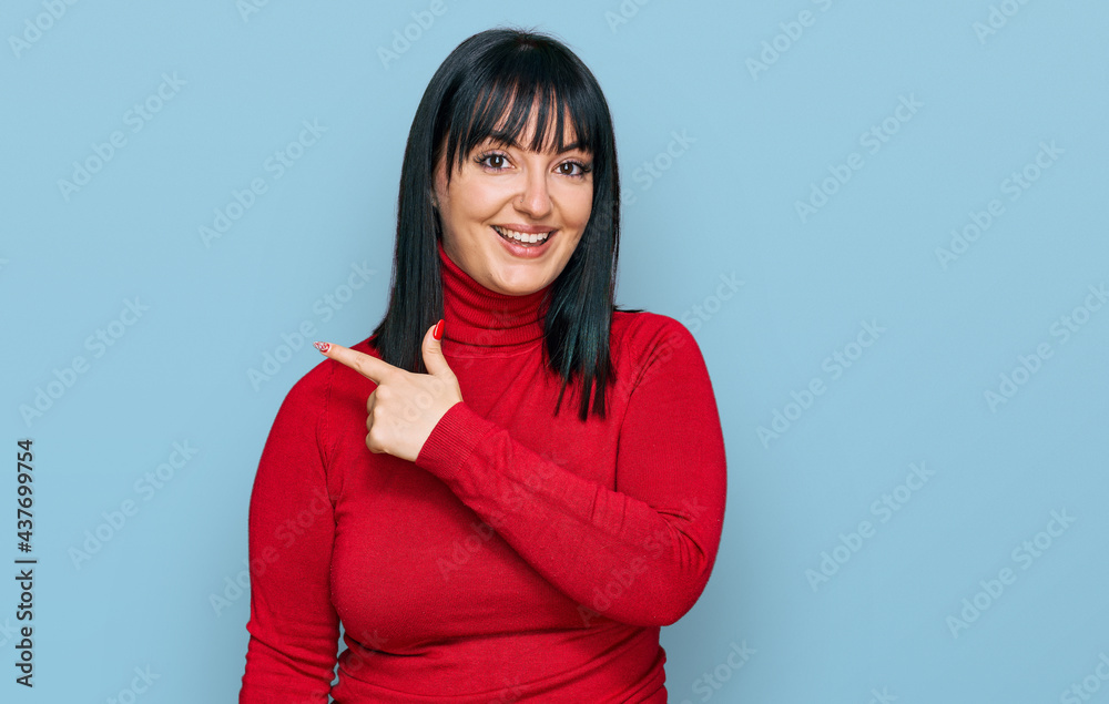 Young hispanic woman wearing casual clothes cheerful with a smile of face pointing with hand and finger up to the side with happy and natural expression on face Young hispanic woman wearing casual clothes cheerful with a smile of face pointing with hand and finger up to the side with happy and natural expression on face