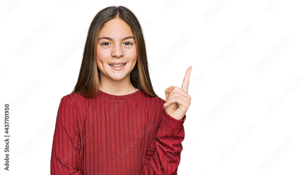 Beautiful brunette little girl wearing casual sweater with a big smile on face, pointing with hand and finger to the side looking at the camera. Beautiful brunette little girl wearing casual sweater with a big smile on face, pointing with hand and finger to the side looking at the camera.