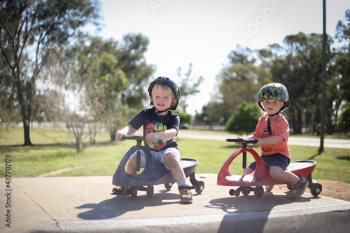 Happy little boys playing on rode on carts at skate park © Caseyjadew