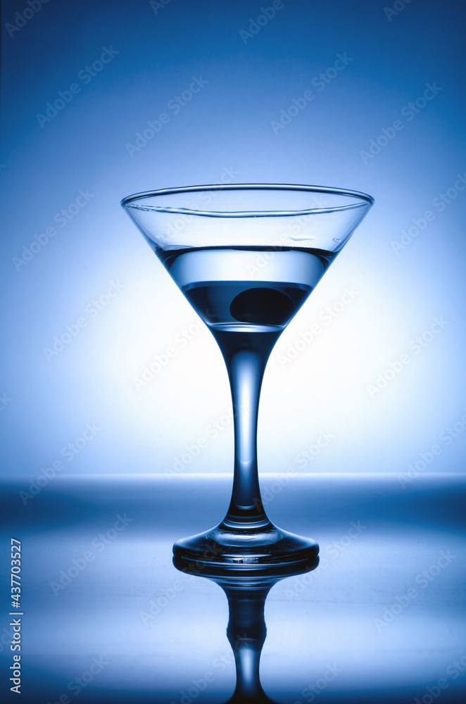 martini glass with olive in blue backlight martini glass with olive in blue backlight
