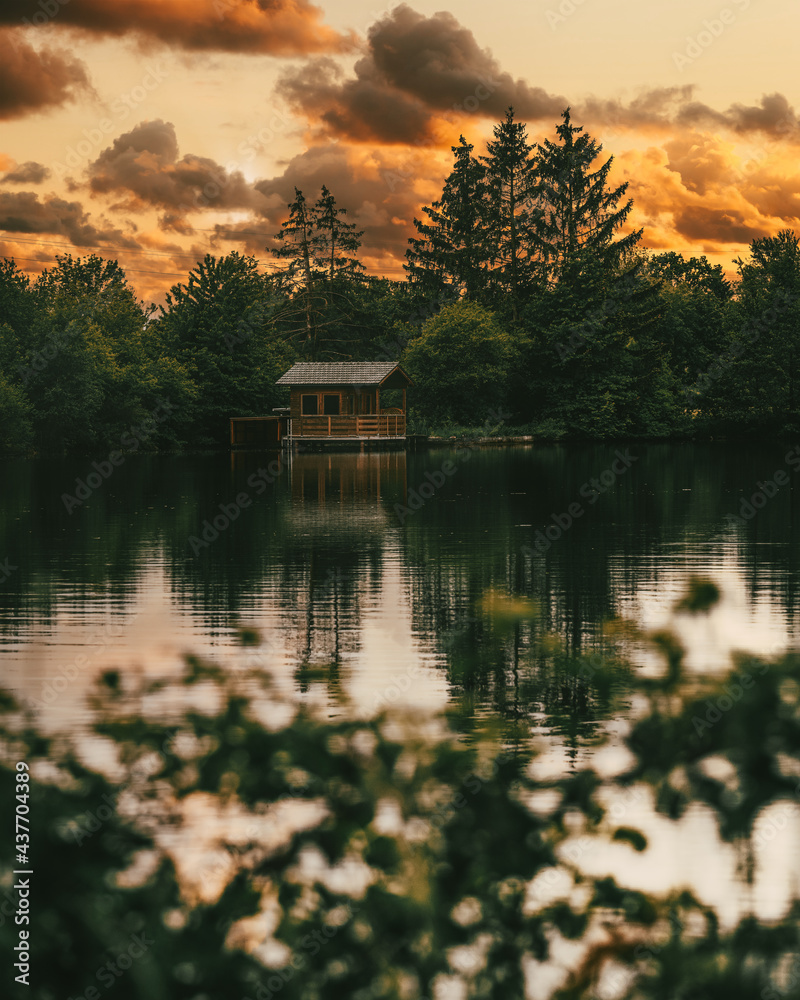 Obraz premium Hütte am See bei Sonnenuntergang