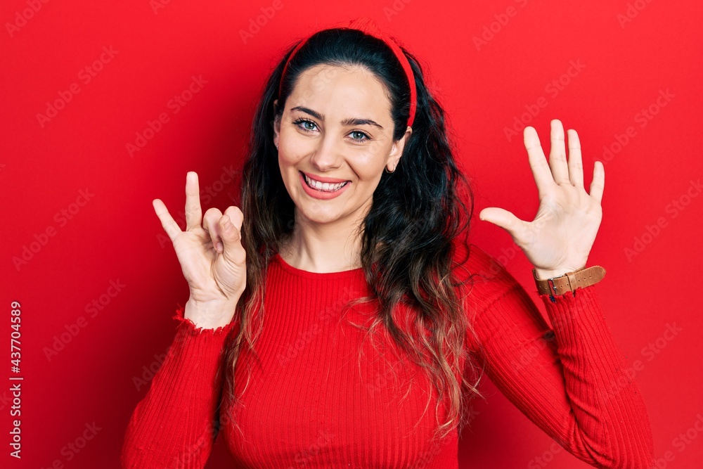 Young hispanic woman wearing casual clothes showing and pointing up with fingers number seven while smiling confident and happy. Young hispanic woman wearing casual clothes showing and pointing up with fingers number seven while smiling confident and happy.