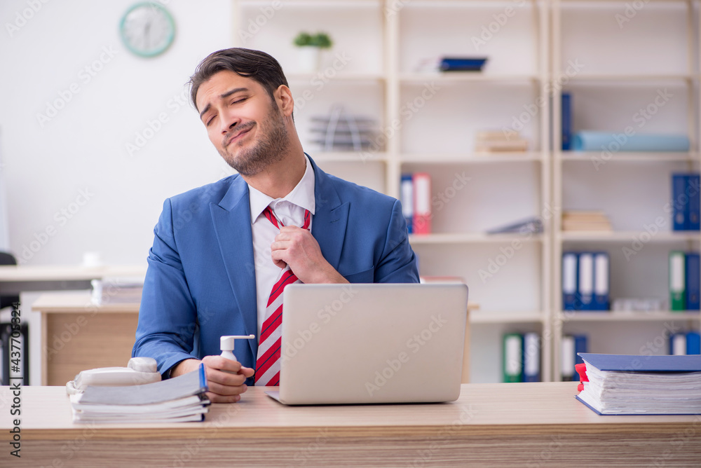 Young male employee suffering at workplace Young male employee suffering at workplace