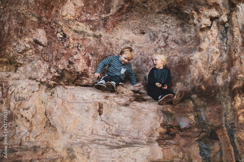 Little boys sitting on rock shelf at The Drip, NSW Australia