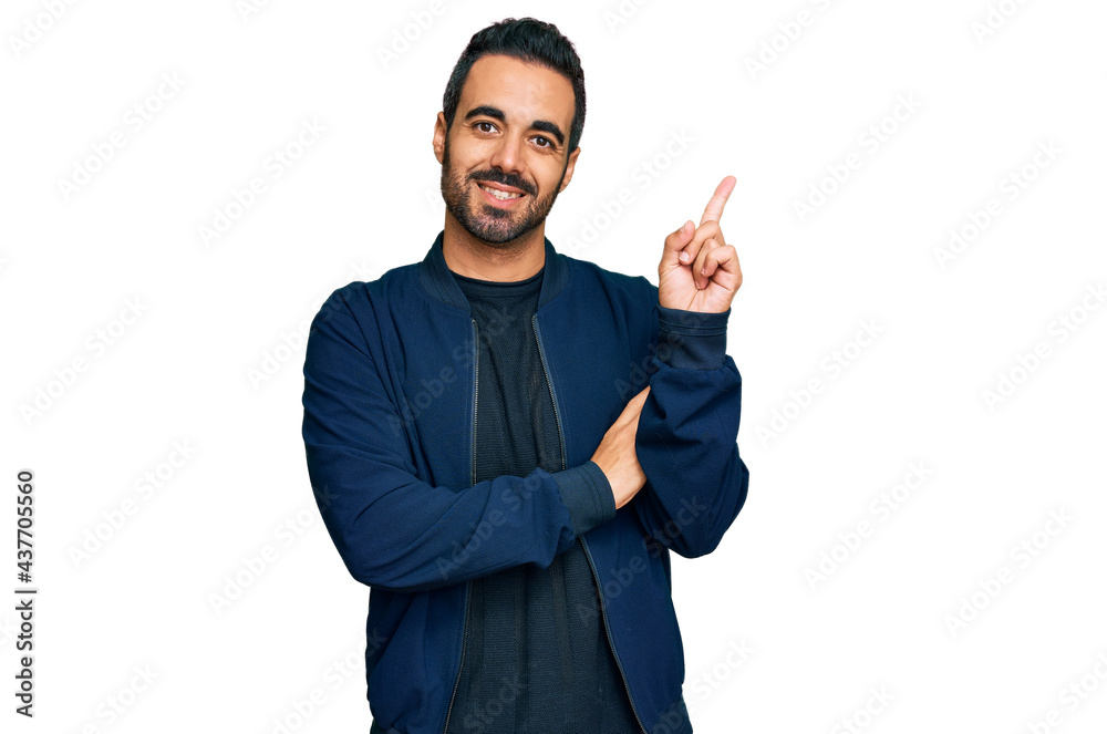 Young hispanic man wearing casual clothes with a big smile on face, pointing with hand and finger to the side looking at the camera. Young hispanic man wearing casual clothes with a big smile on face, pointing with hand and finger to the side looking at the camera.