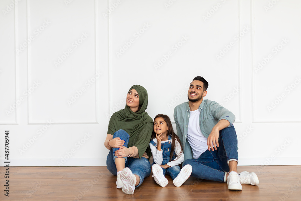 Happy man, woman and girl looking up at home